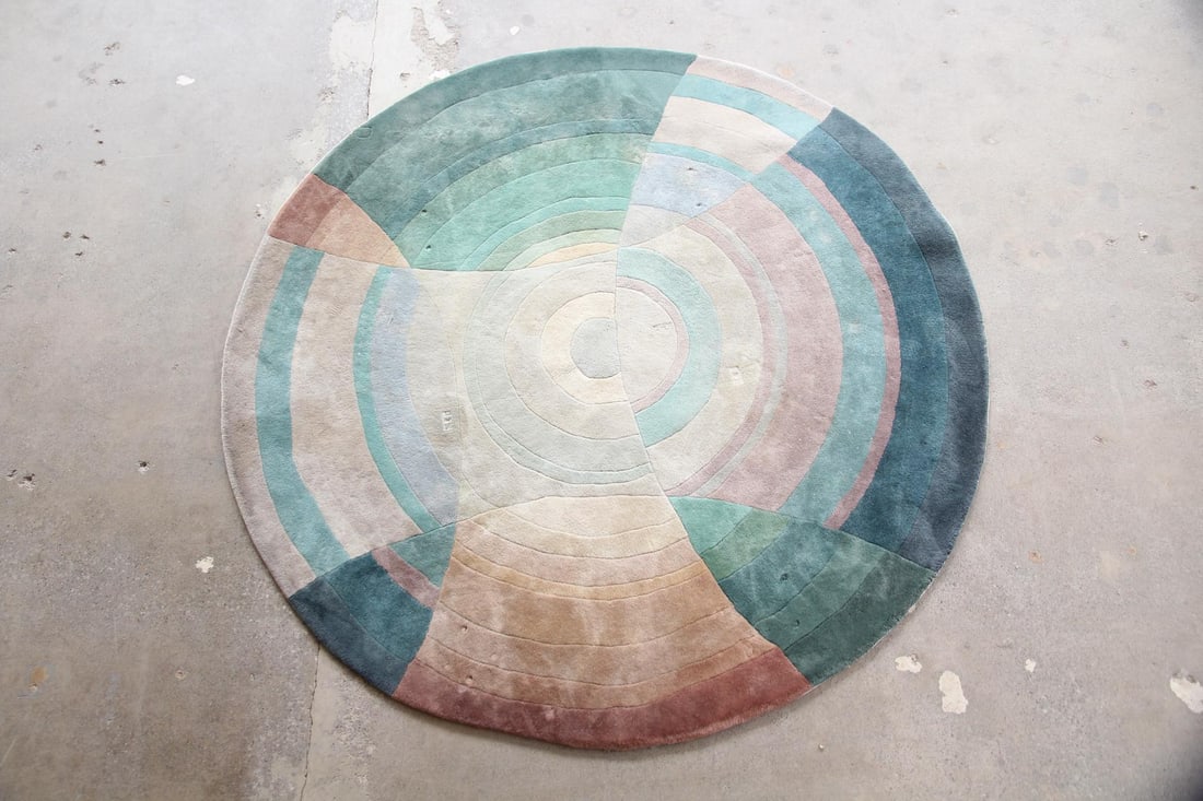 Geometric Abstract Circular Wool Rug, Muted Colors: Abstract Modern Circular Wool Rug, Muted Colors. A circular rug with concentric circles & arcs in a soft palettes of blues, greens, and tans. Plush wool with a dimensional quality. Dimensions are 87 i