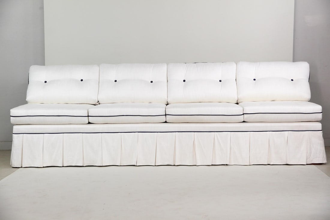 Pleated Cream Silk Armless Sofa, 9.5 Ft Wide: Pleated Cream Silk Armless Sofa, 9.5 Ft Wide. Large 4 cushion sofa with tailored box pleat skirt and tufted cushions. Accented with dark blue piping and buttons. Dimensions are 32.5 in h x 114.5 in w