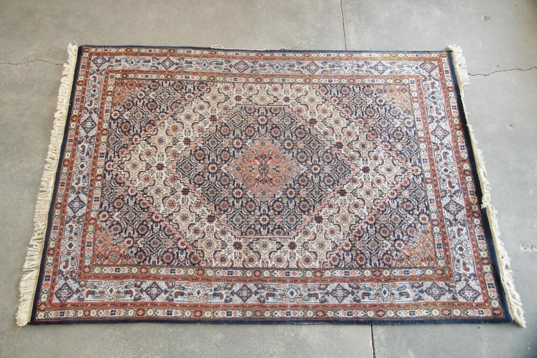 Indo-Persian Floral Wool Rug: Indo-Persian Floral Wool Rug. A hand knotted rug featuring traditional center medallion and small-scale floral and geometric motifs. Made of wool on cotton ground with fringed ends, in tones of peach,