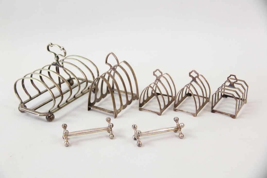 Lot of 5 Toast Racks (4 Sterling Silver) & 2 Knife Rests: Lot of 5 Toast Racks (4 Sterling Silver) & 2 Knife Rests. Includes 4 toast racks with the lion passant as well as Sir John Bennett London mark, 1 silver plate toast rack and 2 unmarked knife rests. Th