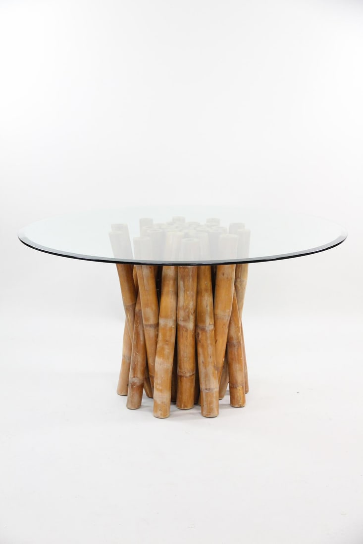 Mid-Century Modern Sculptural Bamboo & Glass Dining Table: Mid-Century Modern Bamboo & Glass Dining Table. Dining table with a clustered bamboo base and a round glass top. Dimensions are 30 in h x 54 in w x 54 in d. Base is 24 in w. Condition is good with