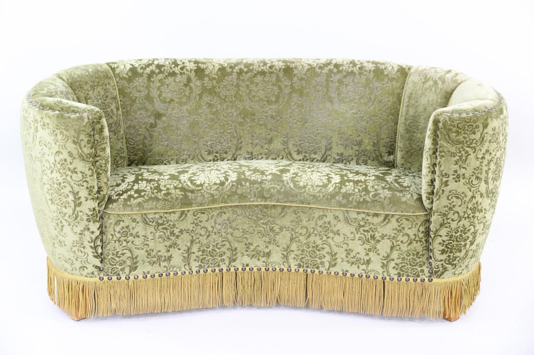 Green Cut Velvet Banana Sofa, Tassle: Danish Mid-Century Modern Green Cut Velvet Banana Sofa. Striking sofa upholstered in green cut velvet, with nailhead trim and gold fringe along the bottom edge. Dimensions are 29.5 in h x 63 in w x 33