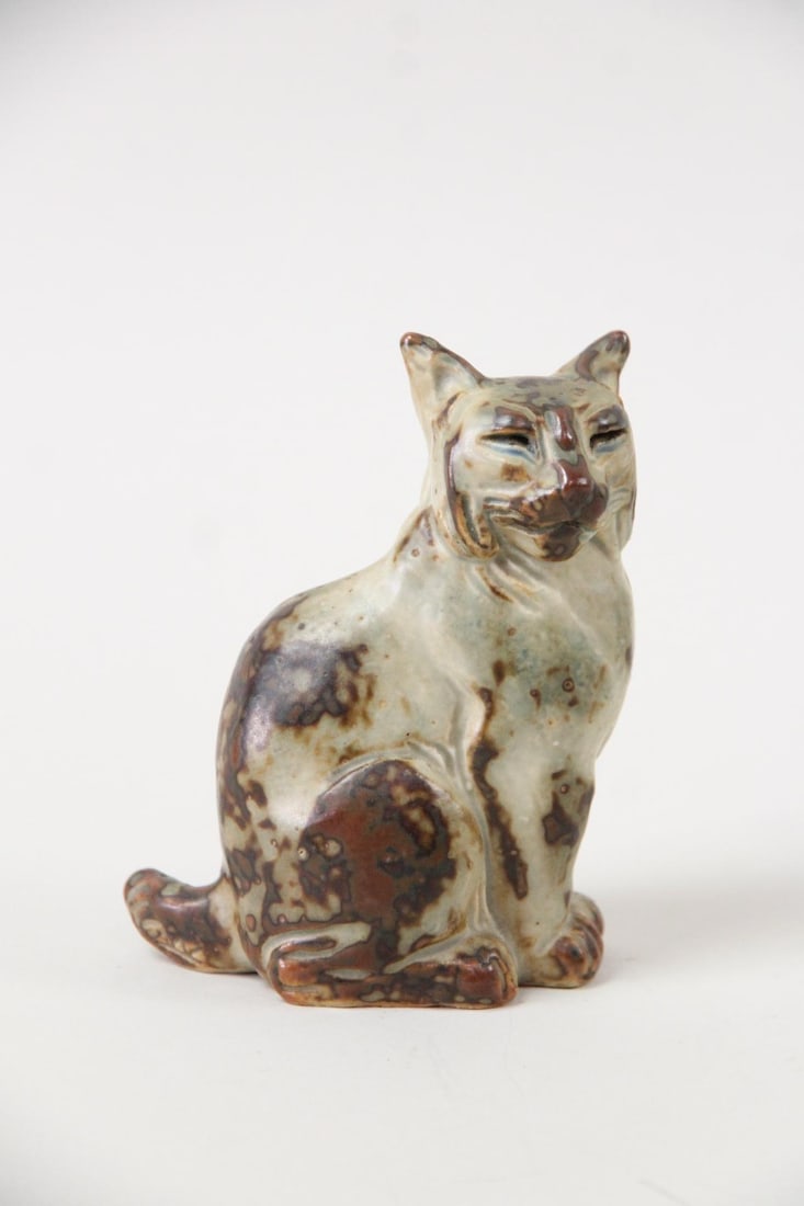 Knud Kyhn for Royal Copenhagen Stoneware Lynx Figurine: Knud Kyhn for Royal Copenhagen Stoneware Lynx Cat Figurine. Royal Copenhagen Knud Kyhn #20242 seated lynx figurine with a brown and grey spotted glaze. Marked on underside by the artist. Dimensions ar