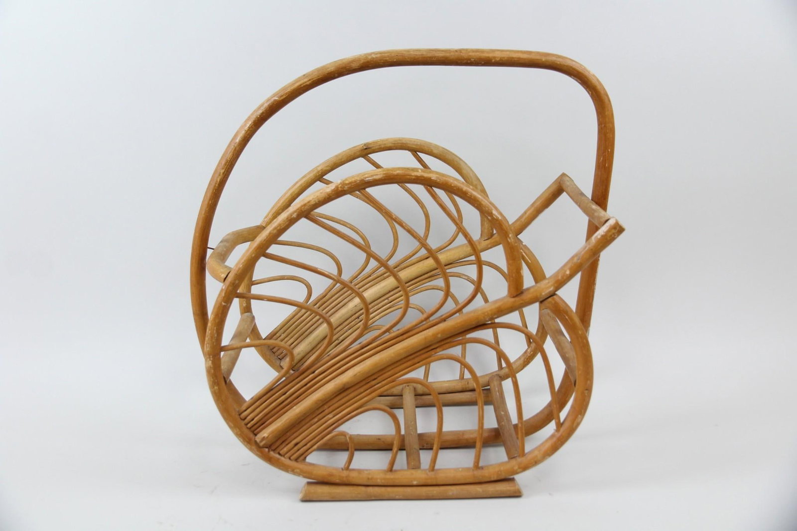 Rattan Magazine Rack in the Form of a Leaf: Mid-Century Modern Rattan Magazine Rack in the Form of a Leaf, Boho. Magazine rack made of rattan, in the shape of a leaf. Dimensions are 20.25 in h x 20 in w x 10.75 in d. Condition is good with scuf