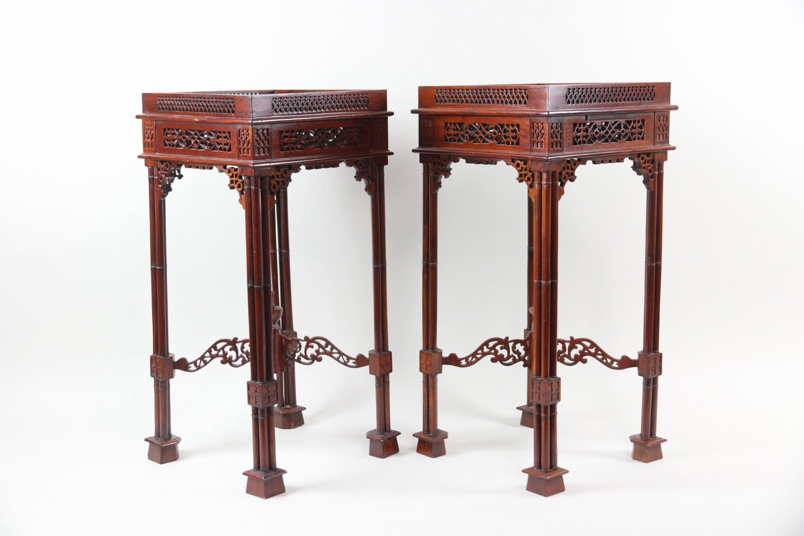 Pair of Chinese Chippendale Mahogany Side Tables: Pair of Chinese Chippendale Mahogany Side Tables, Stands. Matching pair of mahogany side tables with ornate fretwork. Dimensions are 26.5 in h x 13 in w x 13 in d. Condition is good with some surface