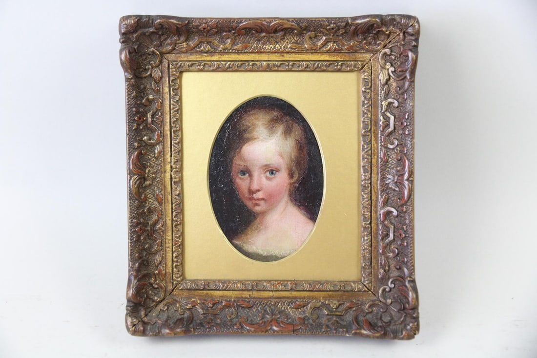 Antique 19th C. Oval Portrait of a Child: Antique Oval Portrait Painting of a Child. Small painting on wood of a child with blue eyes and delicate features. In an ornate gilt wood frame. Dimensions are 9.5 in h x 8.5 in w x 1.75 in d.