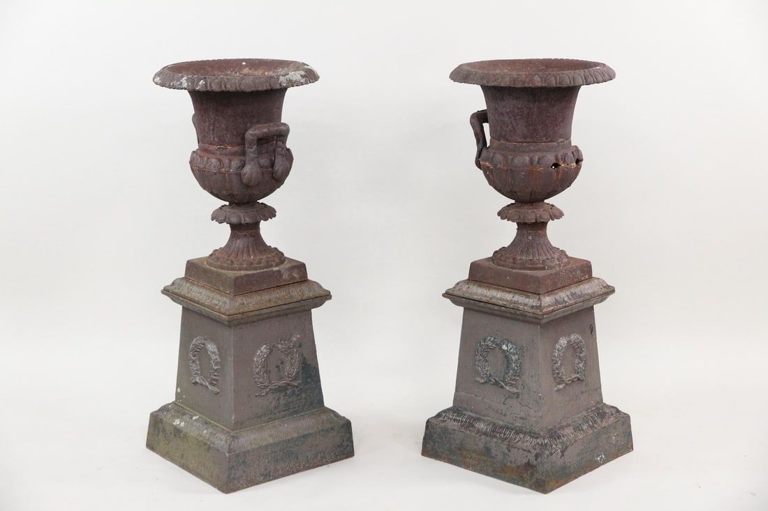 Pair of Large Cast Iron Planter Urns on Pedestals: Pair of Large Cast Iron Planter Urns on Pedestals. Nice matching pair of urns in dark paint. Nice larger scale. Nice leaf patterned bases. Dimensions are 37.5 in h x 15 in w x 15 in d. Condition is go
