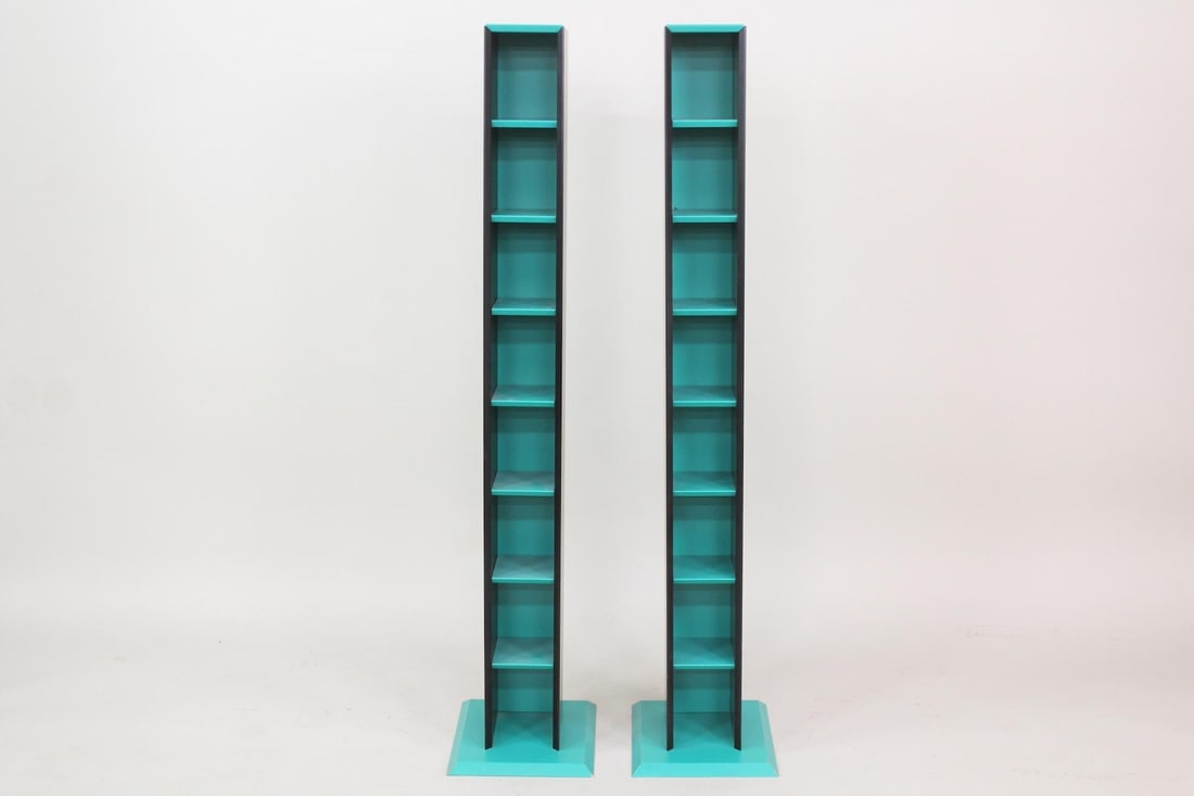 Pair of Memphis Style Shelves, Postmodern CD Racks: Pair of Memphis Style Postmodern CD Racks. These two CD storage towers with 8 shelf spaces lean back at an angle and are painted black and teal blue on raised beveled edge bases. Could be used as disp