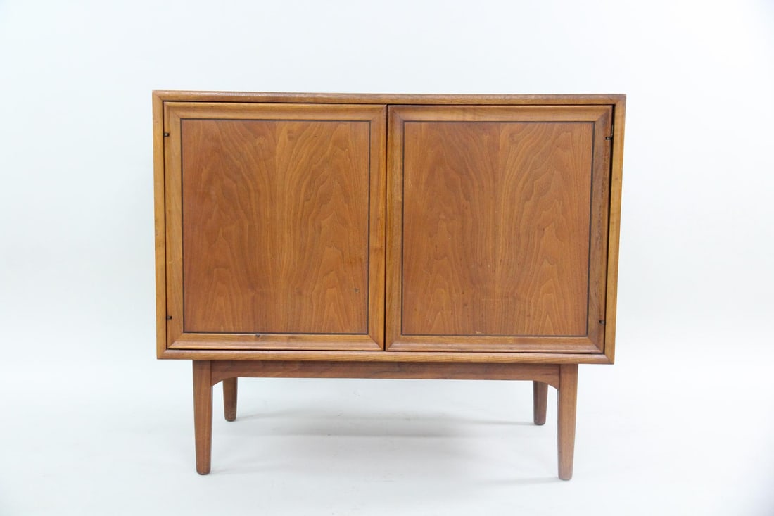 Kipp Stewart for Drexel Wooden Record Storage Cabinet: Mid-century Modern Kipp Stewart for Drexel Declaration Wooden Record Storage Cabinet. A record cabinet made of warm-toned wood with tapered legs and two front doors with interior shelving. With stampe