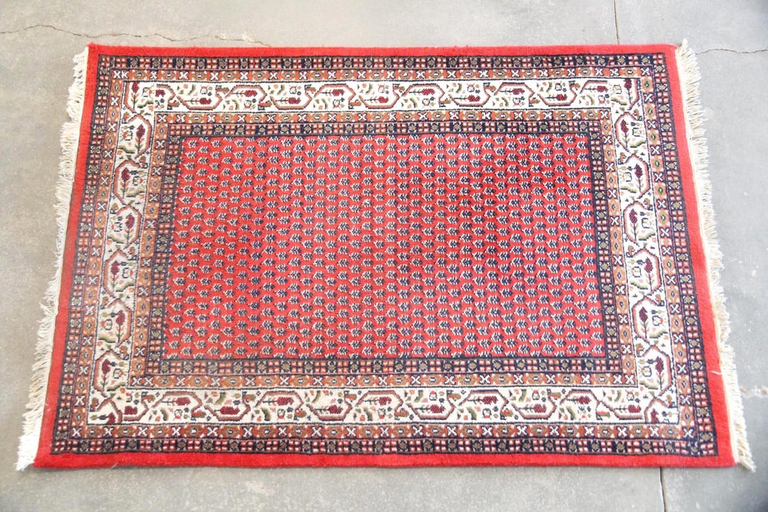 Persian Style Wool Rug, Mir Pattern: Persian Mir Style Wool Rug. A Persian style rug featuring an overall "boteh" or paisley pattern across a vibrant red field with multiple borders. Wool on cotton with a sturdy handle. Dimensions are 55