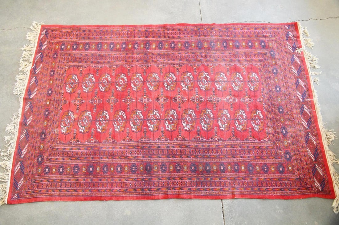 Pakistani Bohkara Mori Wool Rug, 6 x 10 Ft: Pakistani Bohkara Mori Wool Rug, 6 x 10 Ft. A hand-knotted wool rug with traditional Bokhara pattern, featuring organized gul motifs in orange, white, and navy on a red field. Dimensions are 118 in l 