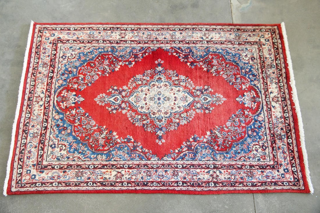 Persian Style Wool Rug, Red Floral: Persian Style Wool Rug, Red Floral. A traditional style rug featuring an ornate floral medallion on a bright red field, with smaller blue, tan, white, and red floral borders. Wool on cotton foundation