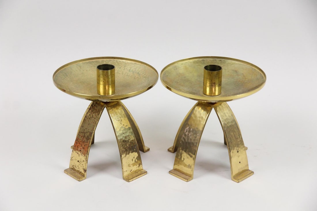 Pair of Mid-Century Modern Hammered Brass Candlesticks: Pair of Mid-Century Modern Hammered Brass Candlesticks. Matching pair of candlesticks made of hammered brass with 4 raised legs and red accents. Dimensions are 6.5 in h x 6.5 in w x 6.5 in d. Conditio