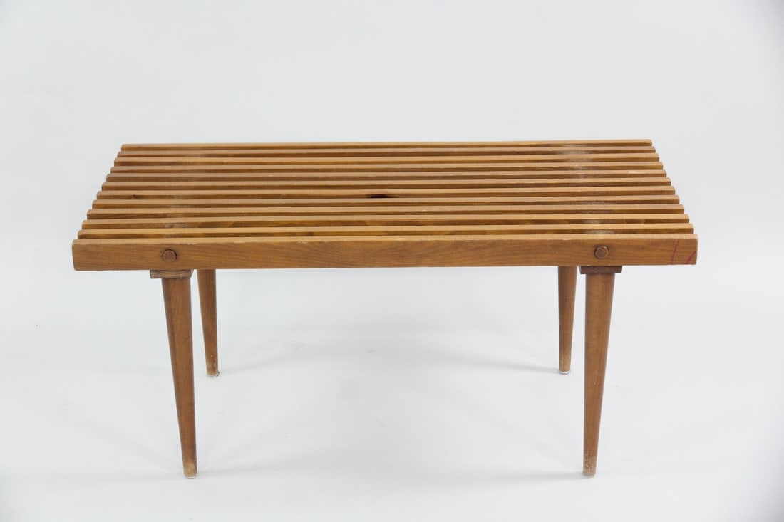 Slatted Wood Bench Coffee Table: Mid-century Modern Slatted Wood Bench or Coffee Table. With a slatted top and tapered legs. Dimensions are 16.75 in h x 35 in w x 17.5 in d. Condition is good with some stains, scuffs and water mark s