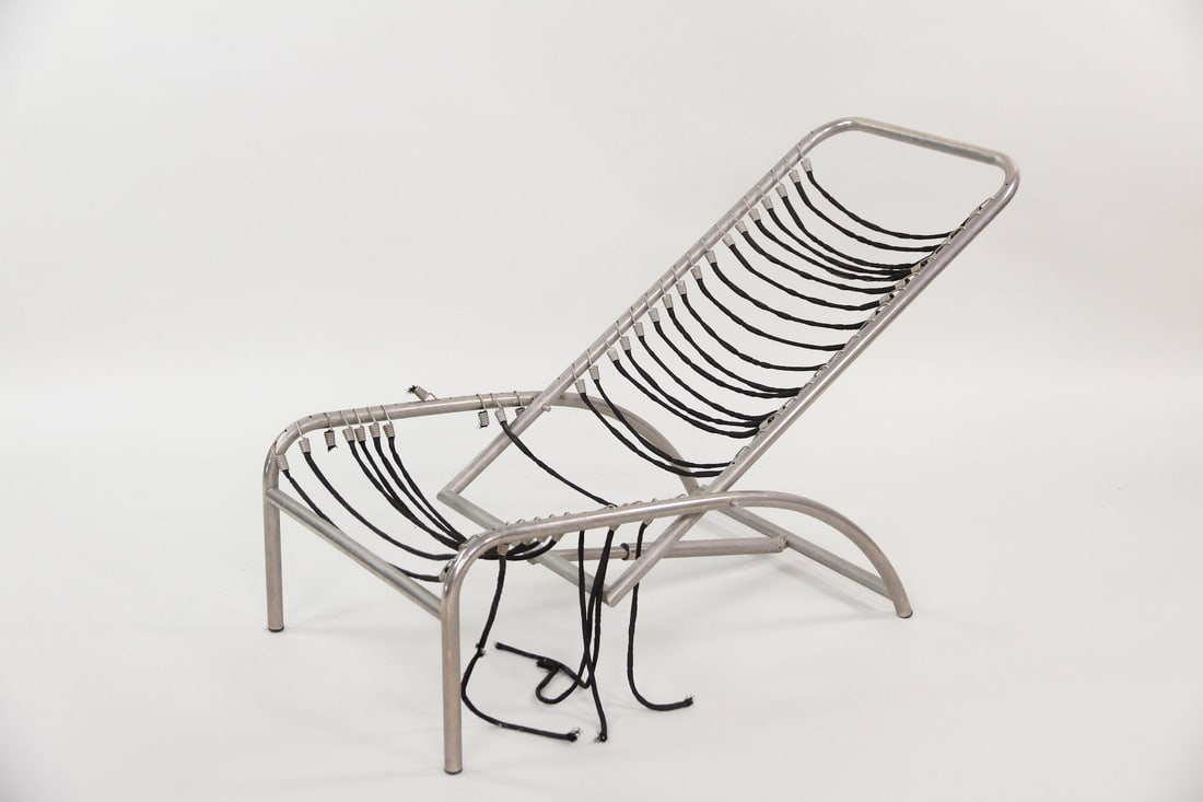 Rene Herbst Sandows Chaise Lounge, Project: Rene Herbst Sandows Chaise Lounge, Pproject. Chaise with tubular metal frame with black elastic cord strapping. Needs work. Dimensions are 27.5 in h x 22.5 in w x 47 n d. Condition is as-is. Broken co