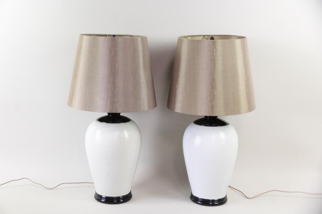 Pair of Nordiska Kompaniet B&W Ceramic Lamps: Pair of Nordiska Kompaniet B&W Ceramic Lamps. Matching pair of ceramic lamps with white ceramic bases with black accents and textured fabric shades. Dimensions are 25.5 in h x 8 in w x 8 in d for the 
