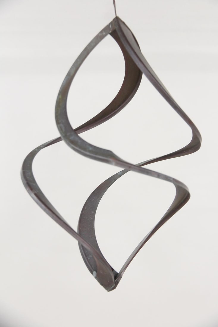 Copper Kinetic Hanging Wind Sculpture: Kinetic Metal Hanging Wind Garden or Porch Sculpture. A double helix-style metal wind spinner with a twisted, looping design that rotates in the breeze. Dimensions are 17 in h x 10.5 in w x 10.5 in