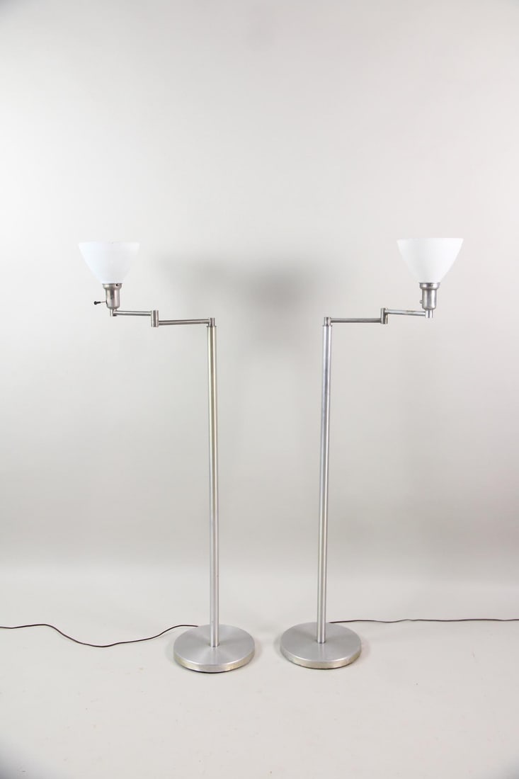 Pair of Walter von Nessen Aluminum Swing Arm Floor Lamps: Pair of Mid-Century Modern Walter von Nessen Swing Arm Floor Lamps. Matching pair of articulated swing arm floor lamps made of aluminum, with milk glass shades. Marked with patent numbers on the