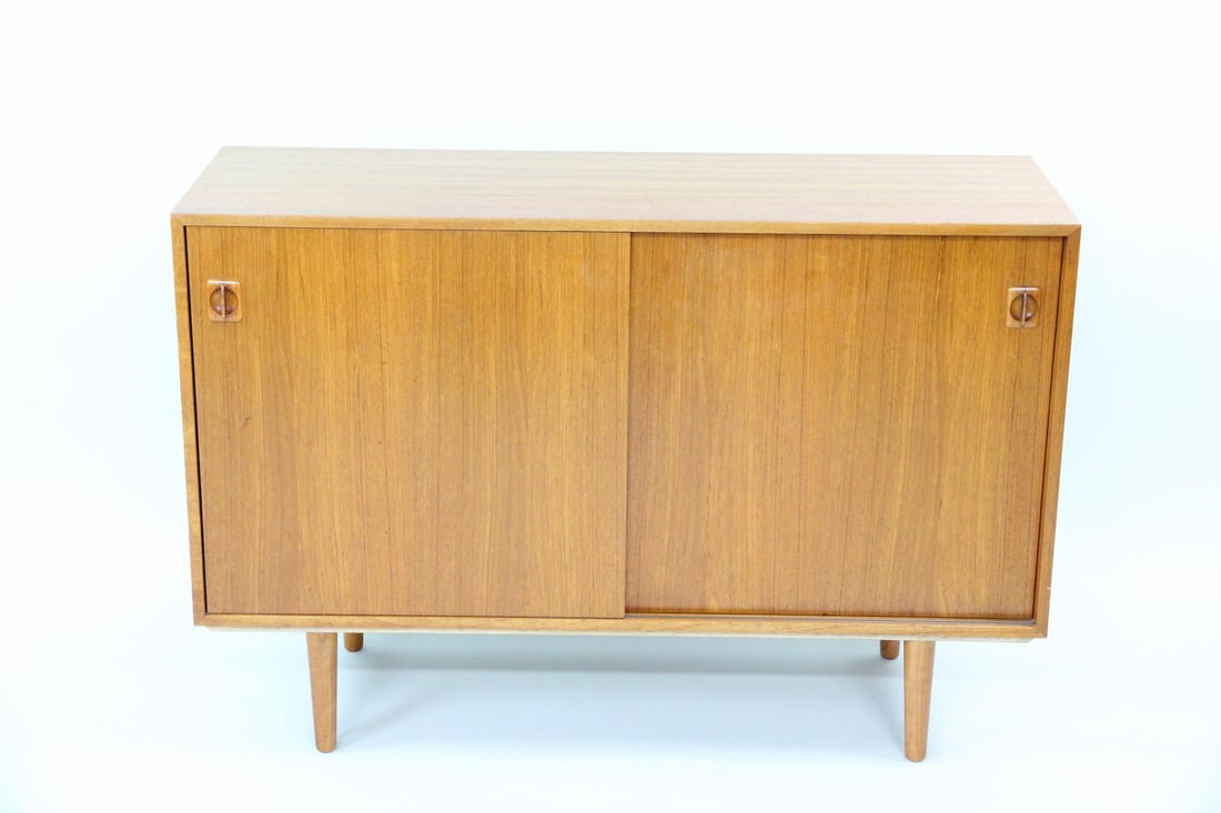 Danish Teak Cabinet, Sliding Doors: Danish Modern Teak Cabinet, Sliding Doors. A cabinet with two sliding doors with sculptural pulls and interior shelves. Made of teak wood with a lovely grain. Dimensions are 32.25 in h x 47.5 in w x