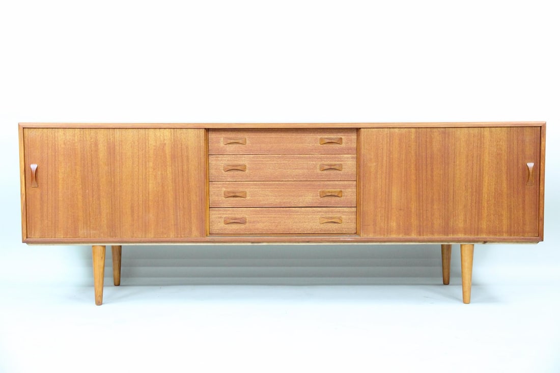 Clausen & Son Teak Credenza, Bow-tie Pulls: Danish Modern Clausen & Son Teak Sideboard. This credenza has sliding doors and four center drawers, all made of warm teak wood with sculptural bow-tie pulls. Labeled Clausen & Son, Denmark to the bac