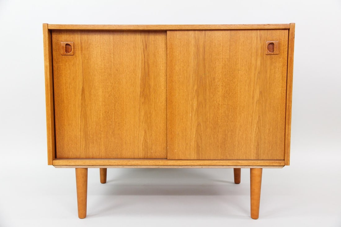 Danish Minimalist Wooden Cabinet, Sliding Doors: Danish Minimalist Wooden Cabinet, Sliding Doors. Low cabinet with two sliding doors featuring sculptural pulls and tapered legs. This unit has two interior shelves. Dimensions are 29 in h x 35 in w x
