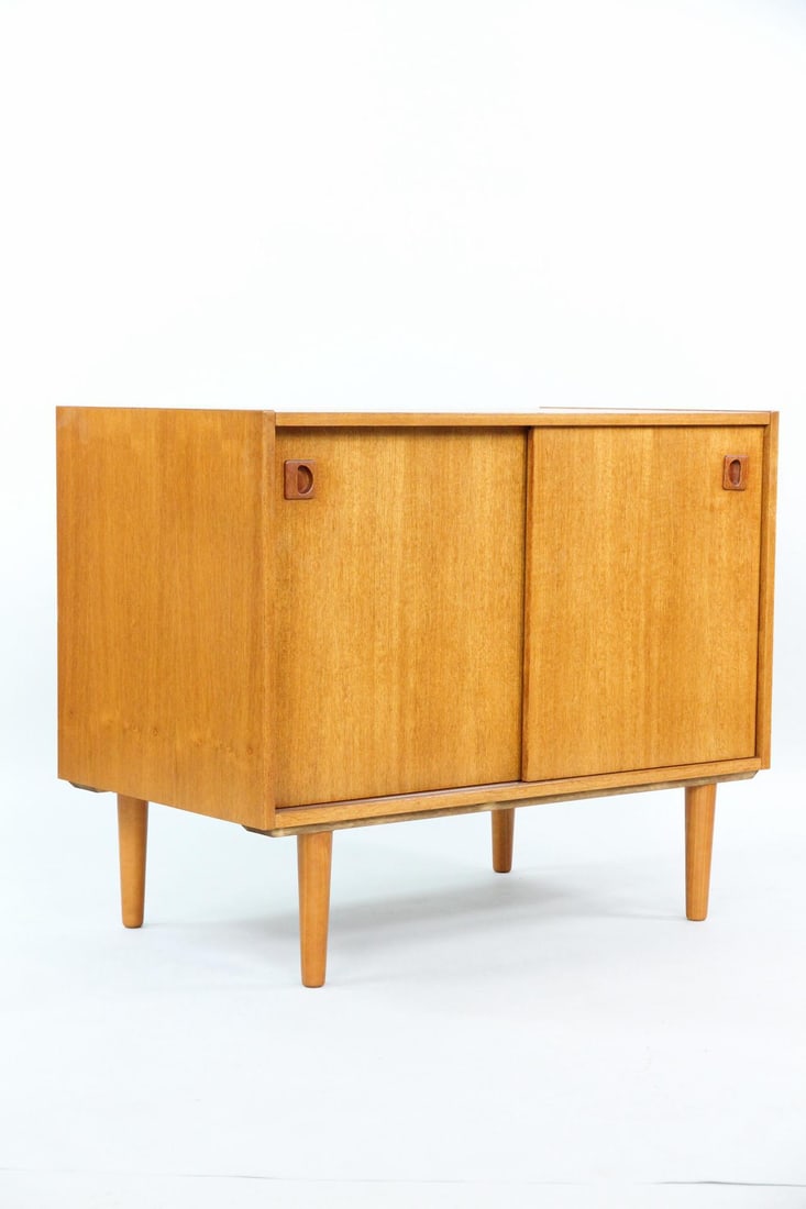 Teak Sliding Door Cabinet, Interior Drawer: Danish Mid-century Modern Teak Sliding Door Cabinet, Interior Drawer. A small cabinet with sliding exterior doors and small, sculptural pulls. The interior has two shelves and one small felt-lined