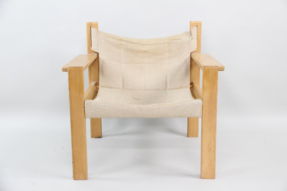 Pine & Canvas Sling Safari Armchair: Pine & Canvas Sling Safari Armchair. Armchair with pine frame and beige canvas sling seat and back. Dimensions are 27 in h x 29 in w x 24 in d. Seat height is 15 in. Condition is fair with a large
