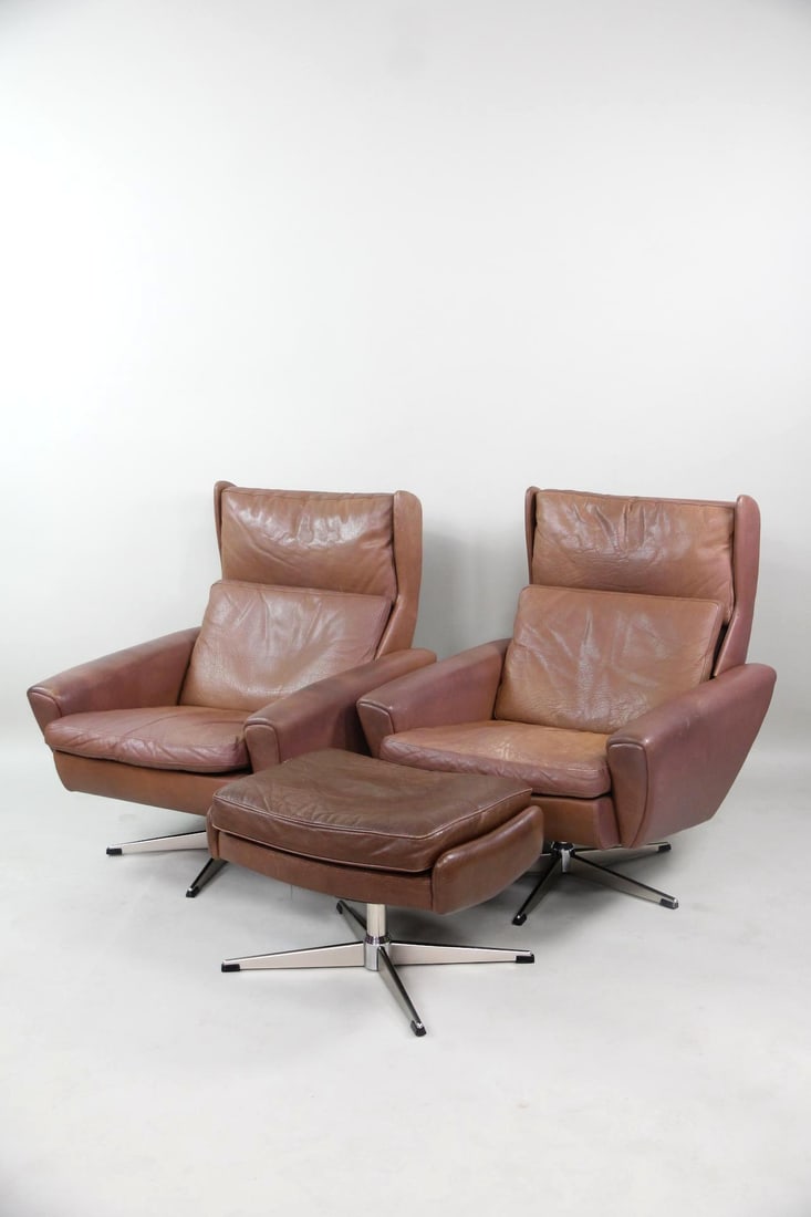 Pair of Leather Swivel Lounge Chairs & Ottoman, George Thams: Pair of Mid-century Modern Leather Lounge Chairs & Ottoman, George Thams. Matching lounge chairs in brown leather with angular silhouettes and metal swivel bases. One matching ottoman included. Unmark