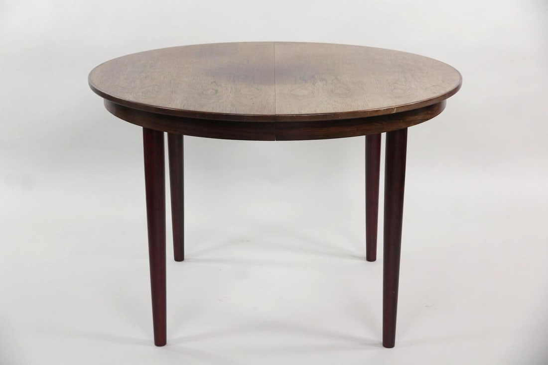 Danish Rosewood Extendable Dining Table: Danish Mid-century Modern Rosewood Extendable Dining Table. A round table in rosewood with two extension leaves. Dimensions are 29 in h x 43.5 in w x 43.5 in d. Length is 83 in. with leaves.