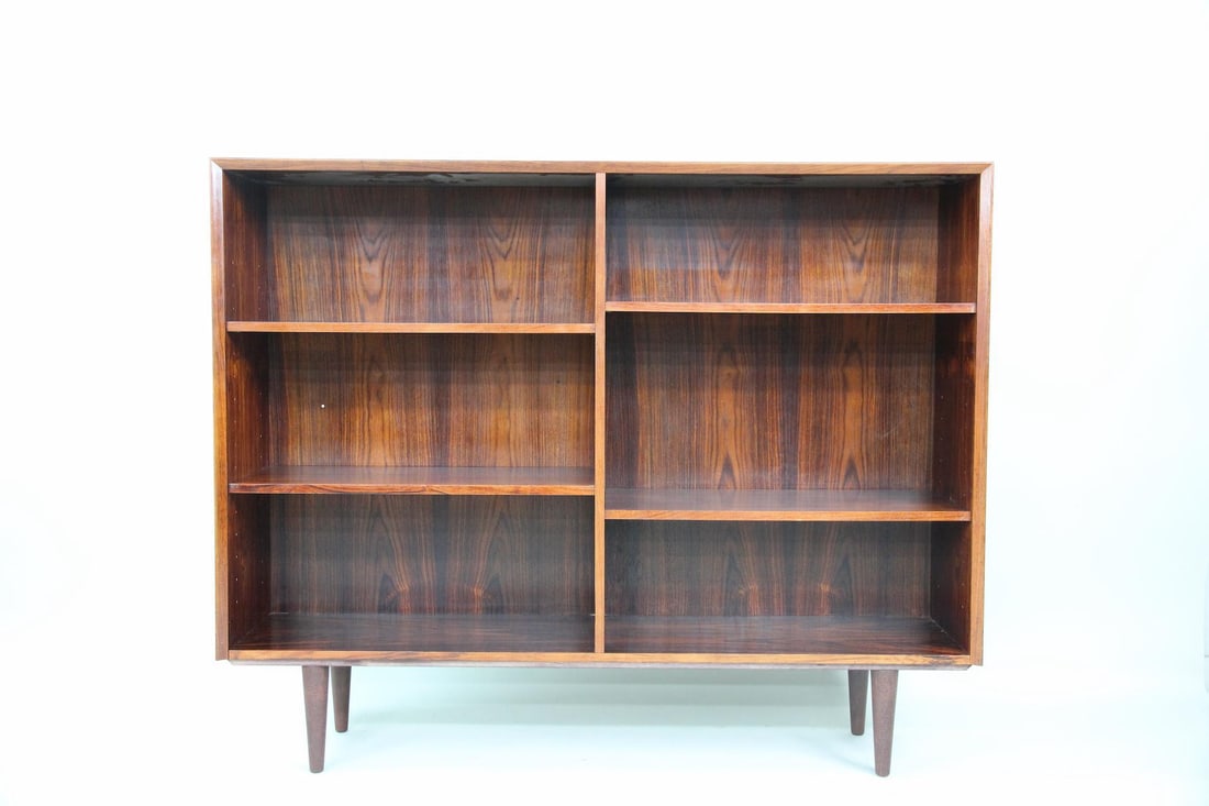 Rosewood Adjustable Bookcase, 1 of 2: Danish Mid-century Modern Rosewood Adjustable Bookshelf, 1 of 2. A minimal bookcase with open, adjustable shelving. Made of rosewood with tapered legs. Dimensions are 43.25 in h x 53.25 in w x 12 in