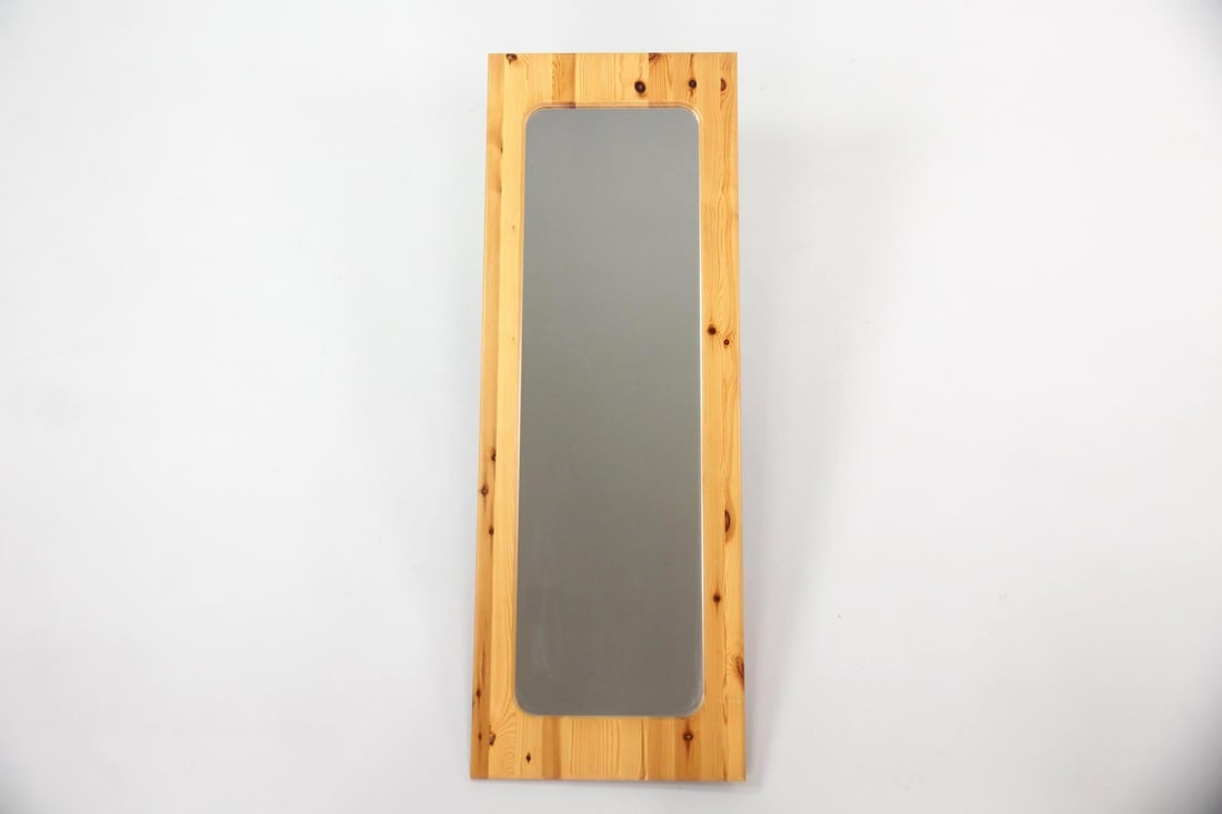 Minimalist Tall Pine Framed Mirror: Tall Danish Modern Pine Mirror. A tall, minimalist mirror with pine frame and nice rounded corner design. Dimensions are 52.25 in h x 18.25 in w x .75 in d. Condition is good with minor wear to edges.