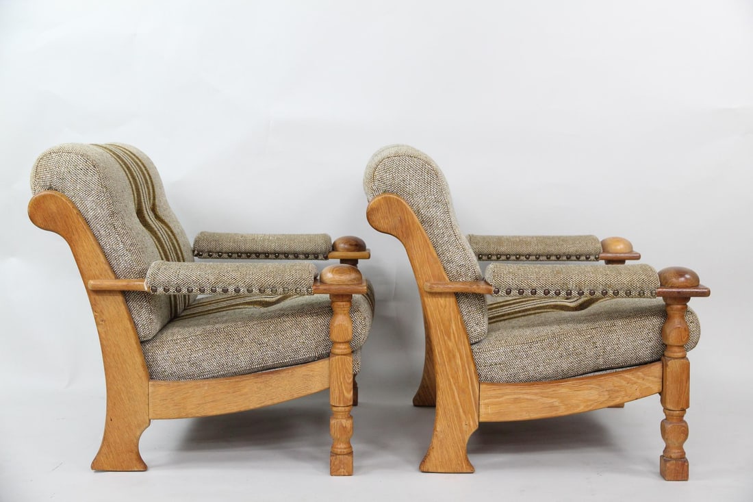 Pair of Upholstered Oak Lounge Chairs, Henning Kjaernulf: Pair of Danish Modern Upholstered Oak Lounge Chairs, Henning Kjærnulf. Pair of comfortable chairs are believed to be by Henning Kjærnulf. Featuring upholstered arms and carved oak frames, with brown
