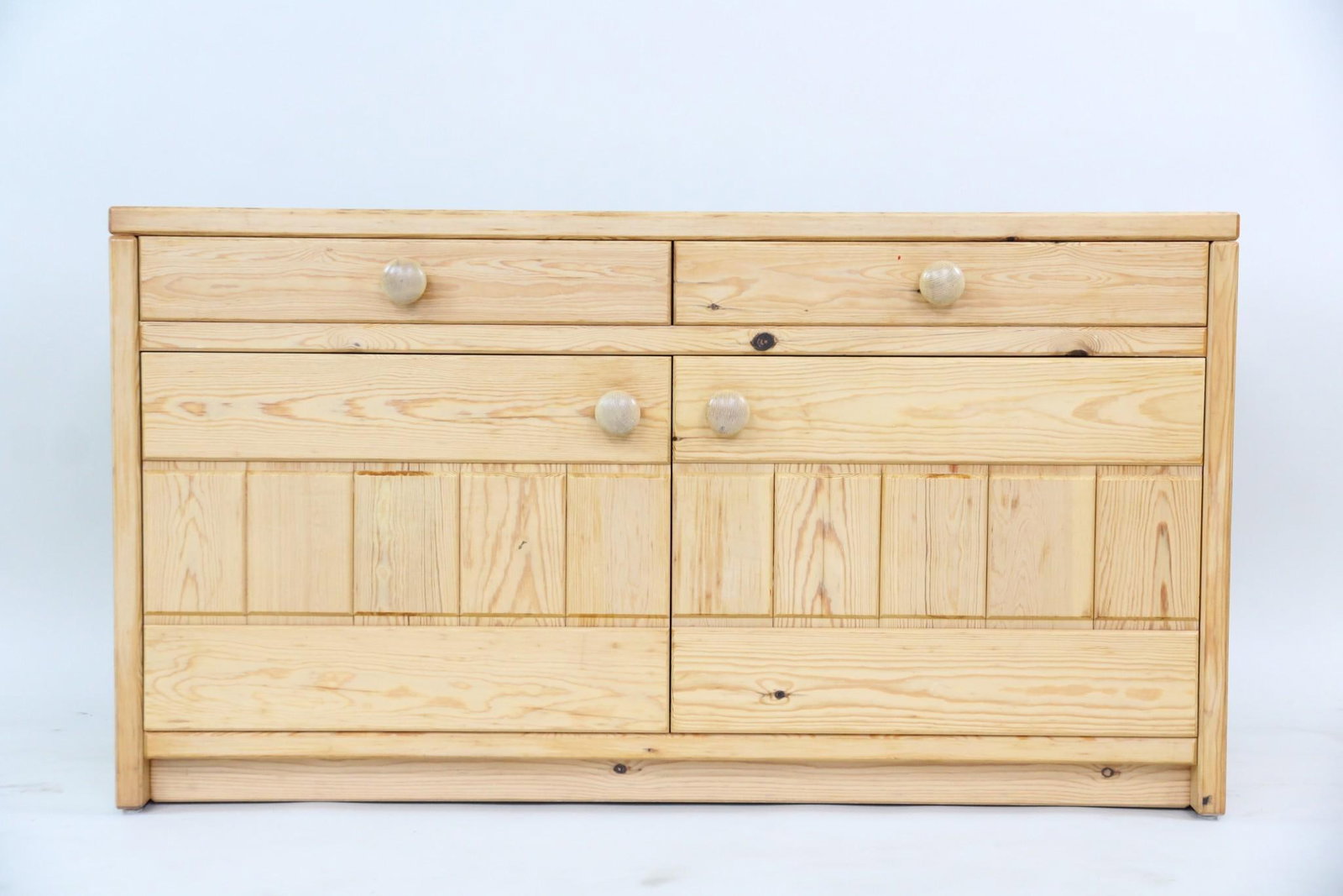 Minimalist Pine Cabinet with Drawers: Minimalist Pine Cabinet Credenza with Drawers. Simple cabinet with two upper drawers, two cabinet doors, and open interior storage. Features large knobs and detailed paneled doors. Dimensions are 26 i