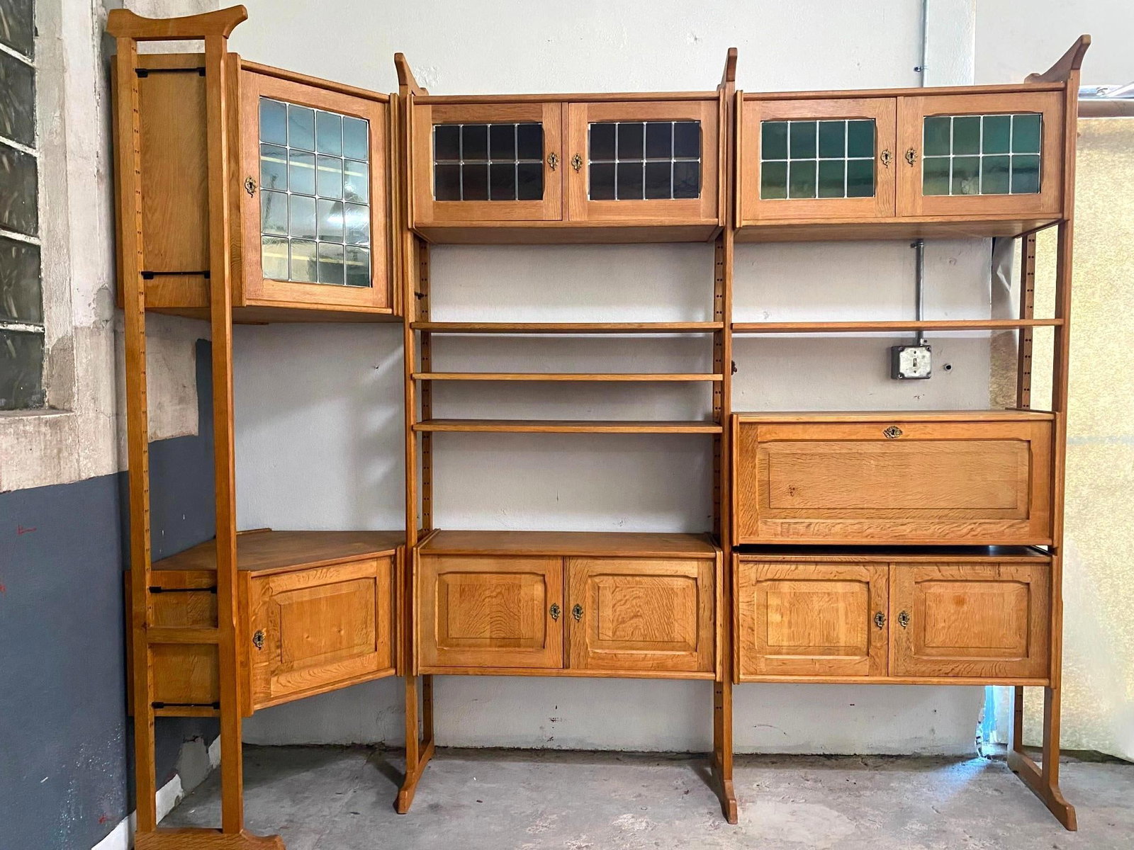 Modular Oak Wall Shelf System Shelving Unit, Henning Kjaernulf: Mid-century Modern Oak Bookcase, Henning Kjærnulf. A modular wall unit featuring multiple oak storage cabinets, open shelving, and glass cabinet doors. In three pieces, made of light oak with brass