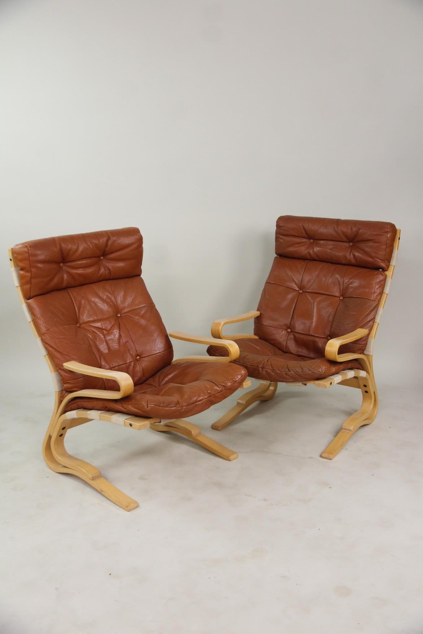 Pair of Skyline Leather Lounge Chairs, Hove Møbler: Pair of Mid-century Modern Skyline Leather Chairs, Hove Mobler. Lounge chairs featuring bentwood frames and brown, tufted leather cushions supported by a canvas sling. Unmarked. Dimensions are 39.5 in