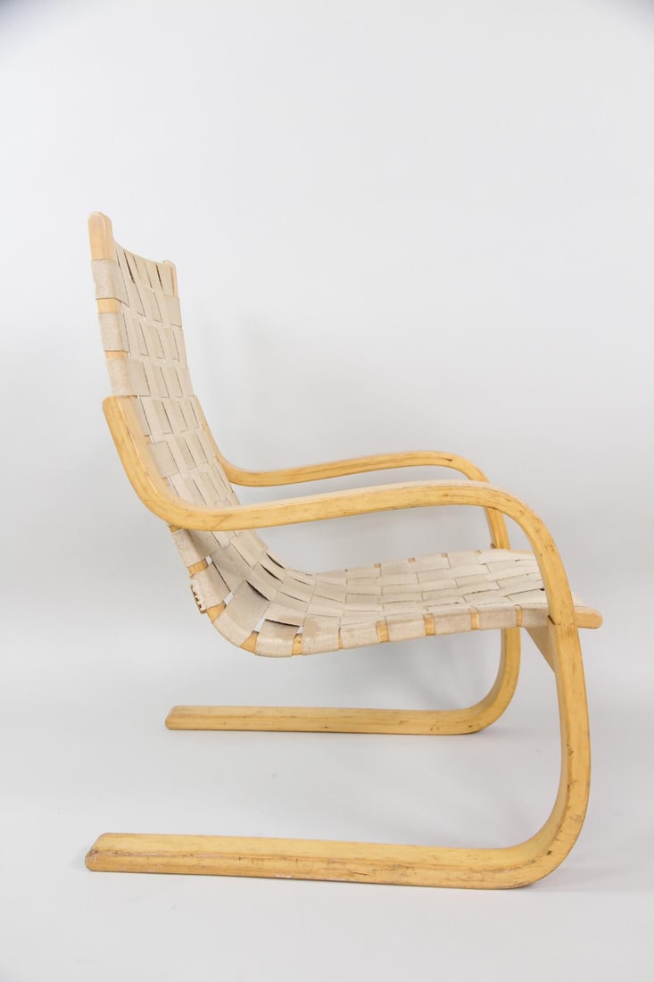 Alvar Aalto Bentwood Lounge Chair 406: Mid-Century Modern Alvar Aalto Lounge Chair 406. Lounge chair with bentwood birch cantilevered frame and canvas strap seat. Unmarked. Dimensions are 34 in h x 24 in w x 28 in d. Seat height is 15 in. 