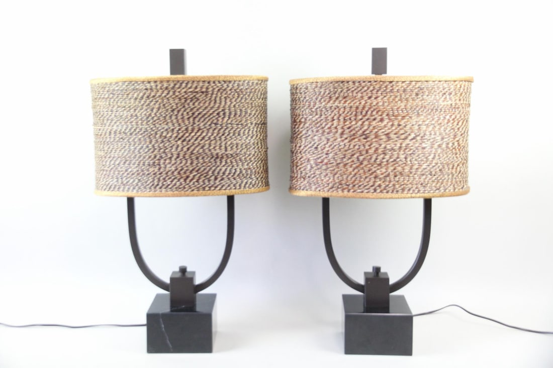 Pair of Sculptural Marble & Rattan Lamps: Pair of Contemporary Marble & Rattan Lamps. Matching pair of lamps with black marble bases, geometric metal frames and contrasting rattan shades. Dimensions of the shades are 11 in h x 17.25 in w x