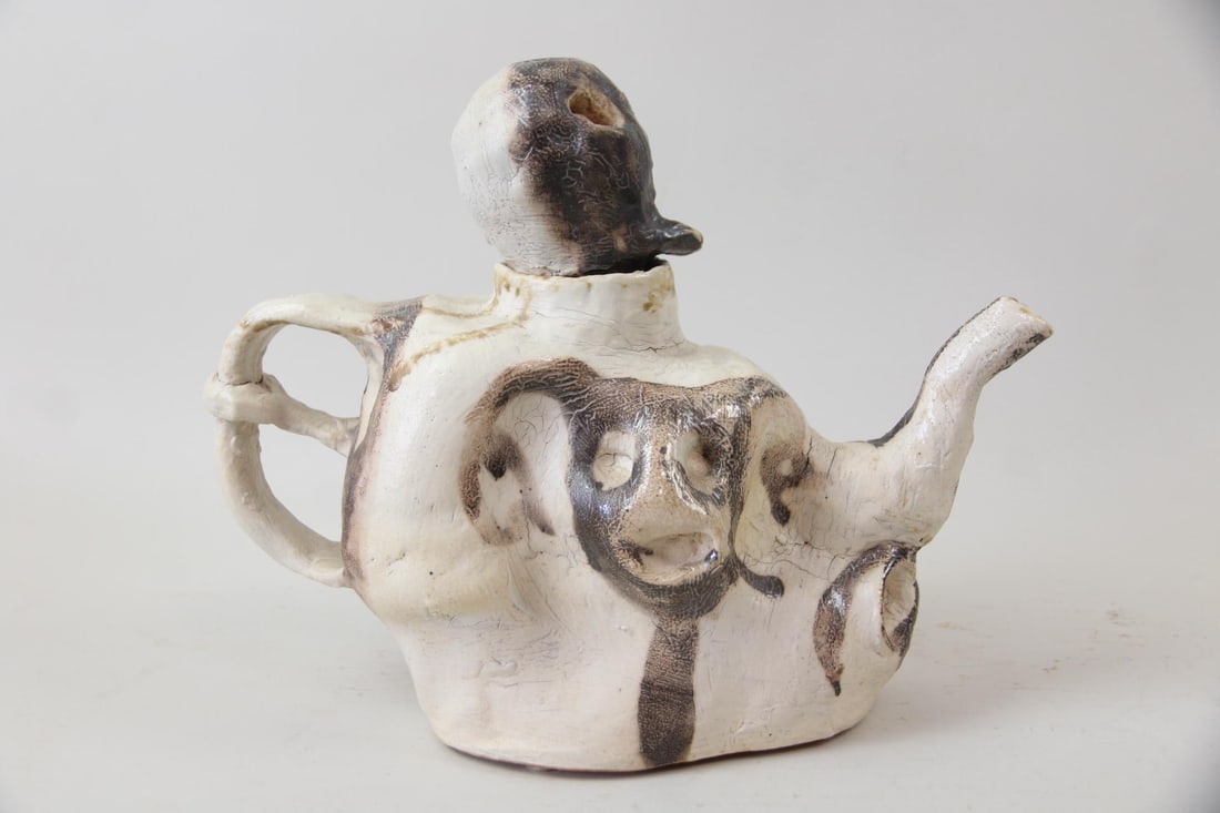 Arnie Zimmerman Skulls Sculptural Teapot, 1999: Arnie (Arnold) Zimmerman Three-legged Face Sculptural Teapot, 1999. An untitled stoneware sculptural teapot with white ground decorated with black skulls. Signed by the artist Arnie Zimmerman