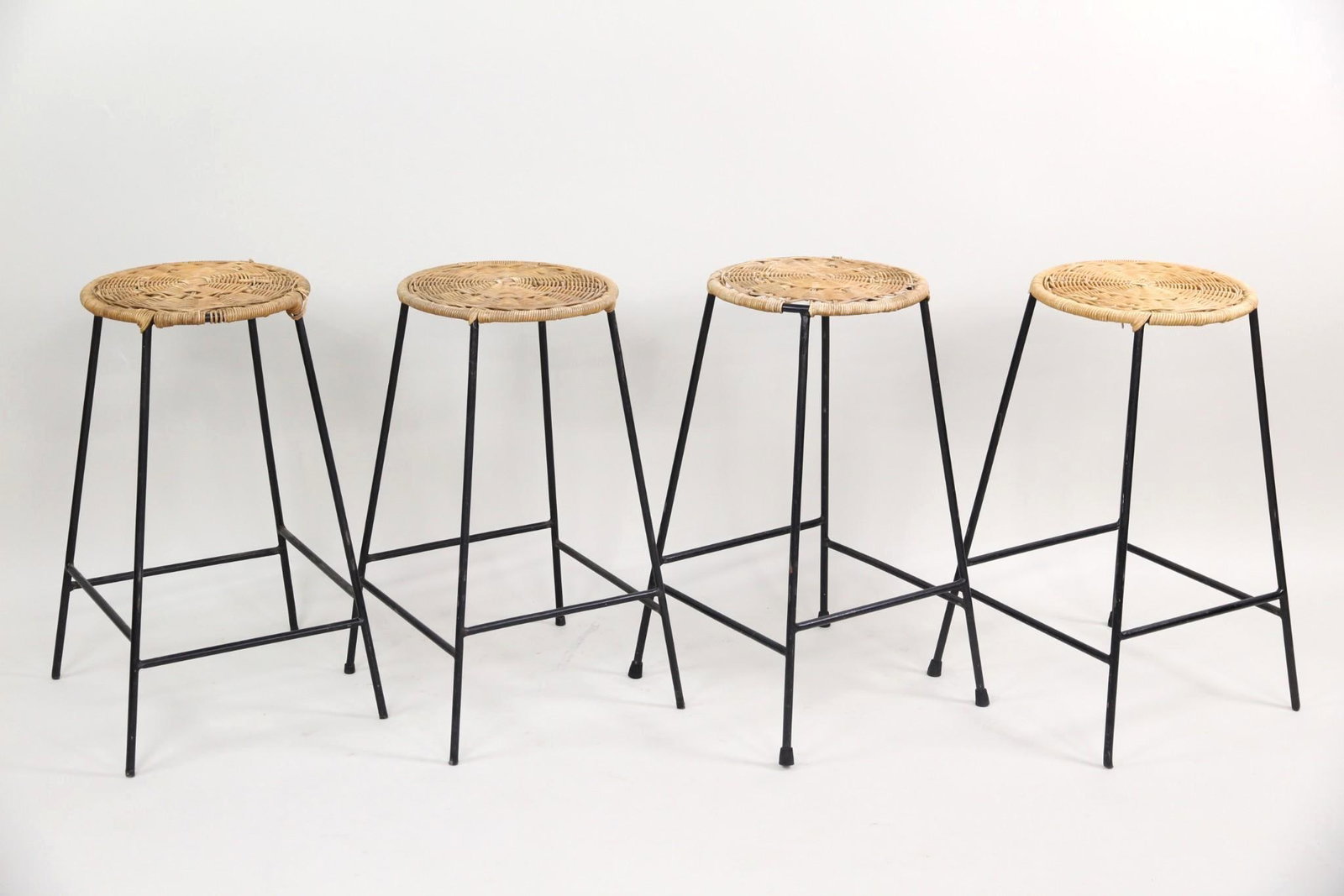 Set of 4 Wicker & Iron Barstools, Arthur Umanoff Style: Set of 4 Wicker & Iron Stools, Arthur Umanoff Style. Matching barstools featuring circular wicker seats and slender iron frames. These are unmarked. Dimensions are 24.25 in h x 12 in w x 15 in d. Cond