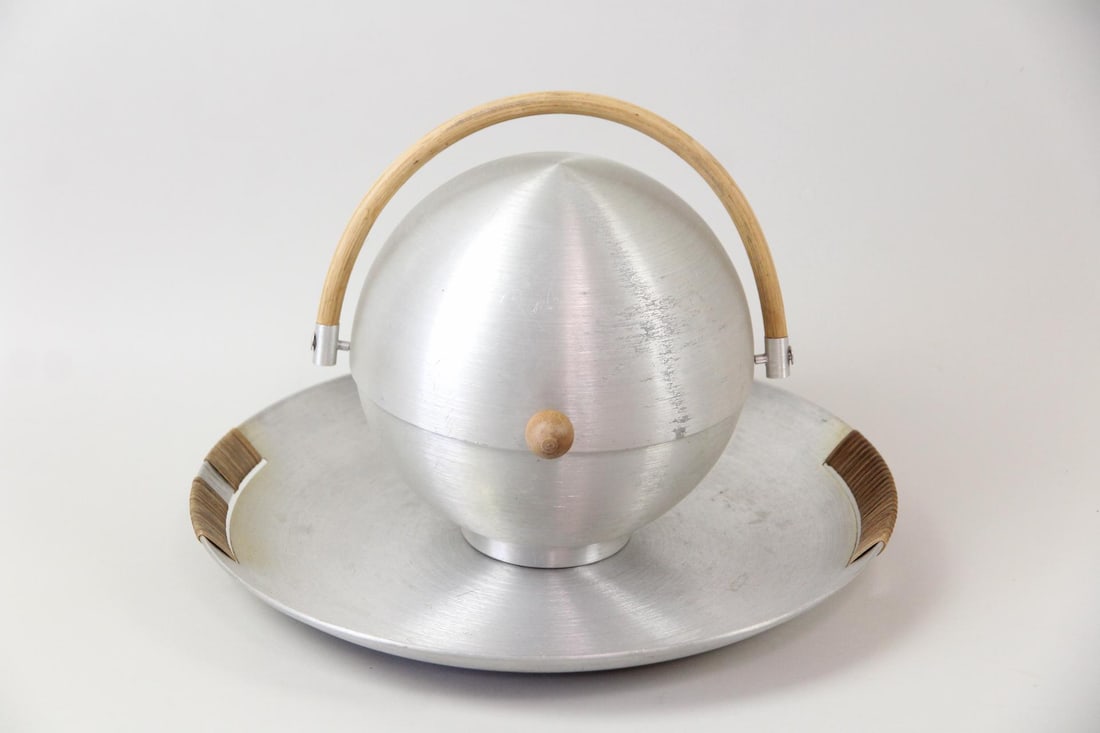 Russel Wright Spun Aluminum Bun Warmer & Serving Platter: Russel Wright Mid-Century Modern Machine Age Spun Aluminum Bun Warmer & Serving Platter. Bun warmer has a wooden handle and knob, and the platter has raffia handles. Both marked Russel Wright on