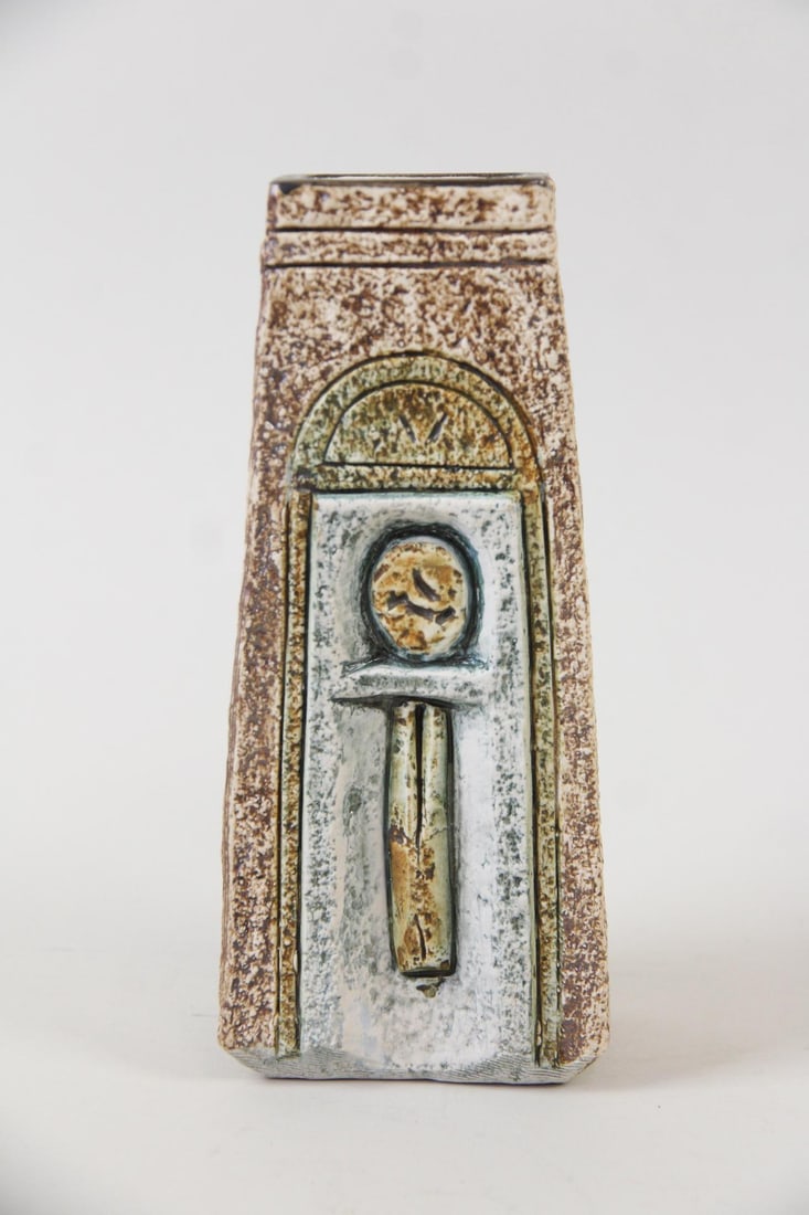 Troika Pottery Coffin Vase: Troika Studio Pottery Coffin Vase. Ceramic vase in brown, green and blue glaze with incised "Stickman" design. Signed Troika on underside. Dimensions are 7 in h x 3 in w x 2.25 in d. Condition is