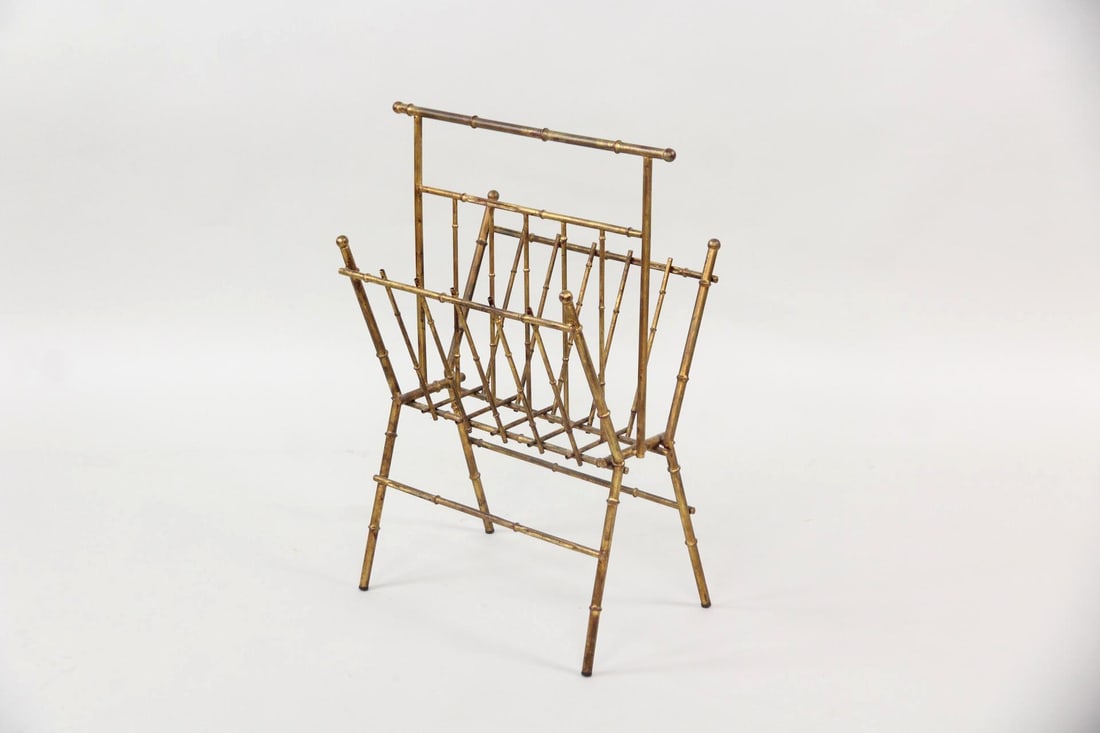 Faux Bamboo Brass Magazine Rack: Mid-century Modern Faux Bamboo Brass Magazine Rack. A magazine rack with distinctive faux bamboo design and gold finish. It has two sides for storage and a carrying handle. Dimensions are 28.5 in h x