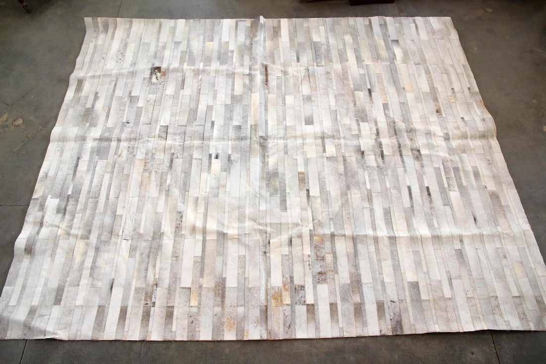 Minimalist Design Within Reach Patchwork Cowhide Rug, 9.5 x 12 Ft: Modern Design Within Reach Thin Strip Cowhide Rug, 9.5 x 12 Ft. A neutral, modern area rug made of carefully sewn individual strips of hide, in tones of cream, white, and gray. With Design Within