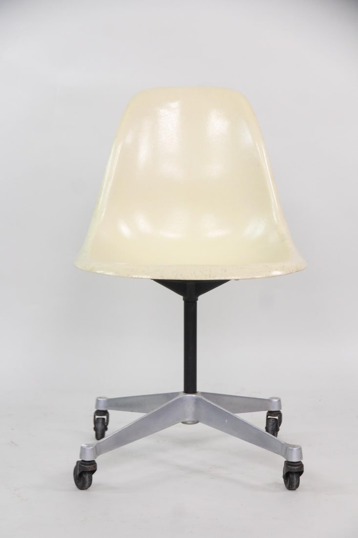 Eames for Herman Miller Fiberglass Shell Swivel Chair on Casters: Eames for Herman Miller Fiberglass Desk Chair on Wheels. Iconic chair with a parchment fiberglass shell on aluminum base with casters. Remnants of patent label to underside with stamped numbers. Dimen