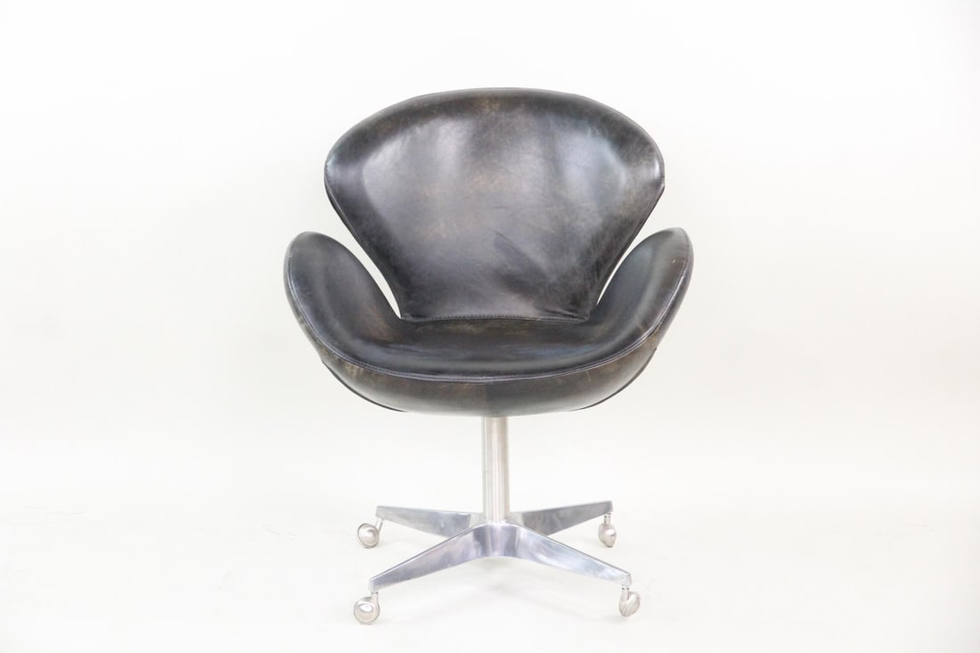 Restoration Hardware Devon Leather Swivel Chair: Restoration Hardware Devon Leather Office Swan Chair. This chair features ergonomic curvature in the Swan chair style. It has a an aluminum base with casters and is covered in brown leather. No labels