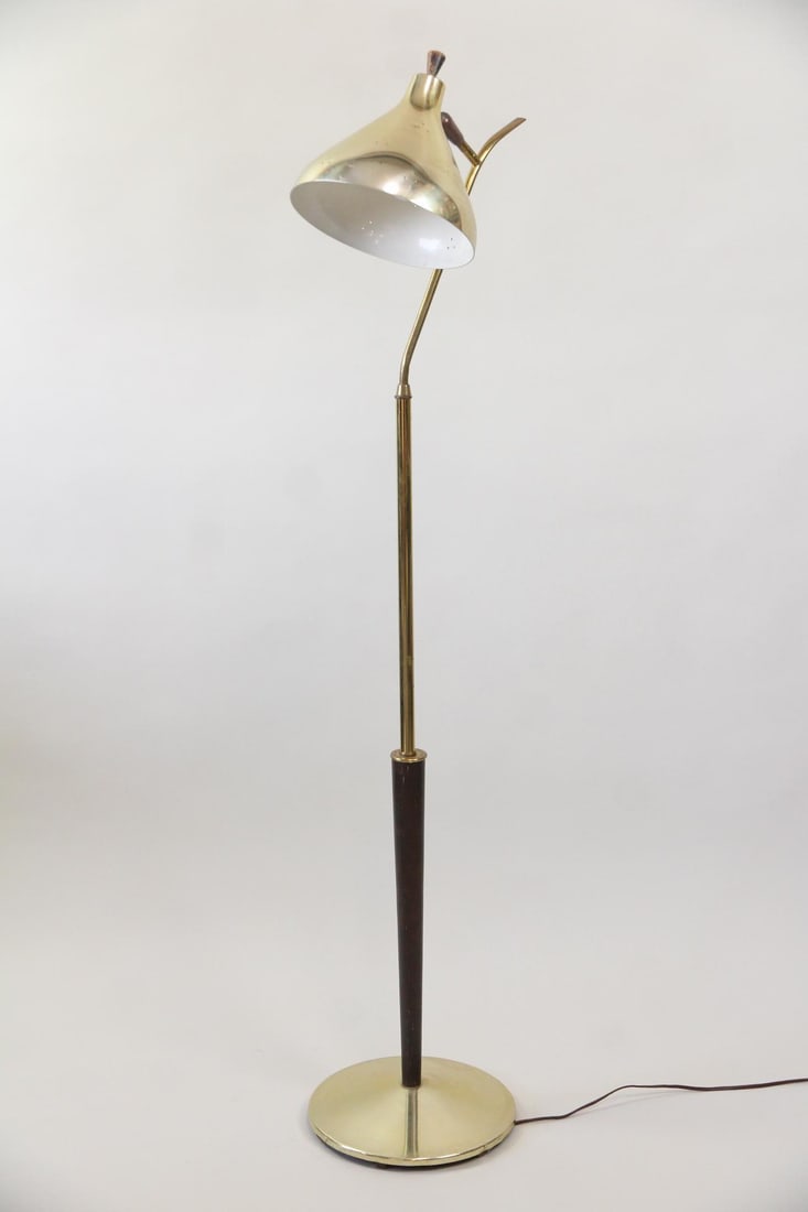 Mid-century Modern Brass & Wood Floor Lamp: Mid-century Modern Brass & Wood Floor Lamp. This lamp features a conical shade with perforations attached to a slender, elegant stem. Made of brass with wood details. Dimensions are 34 in h x 11 in w 