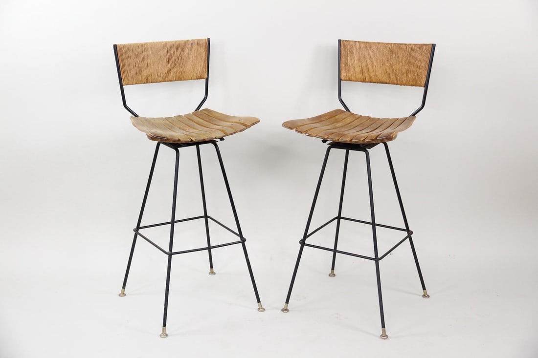 Pair of Arthur Umanoff Barstools, Iron, Wood, & Cord: Pair of Arthur Umanoff Stools, Iron, Wood, & Cord. Pair of barstools with distinctive slatted wood seats, iron bases, and paper cord backs. Unmarked. Dimensions are 41.25 in h x 18.5 in w x 19.5 in d.