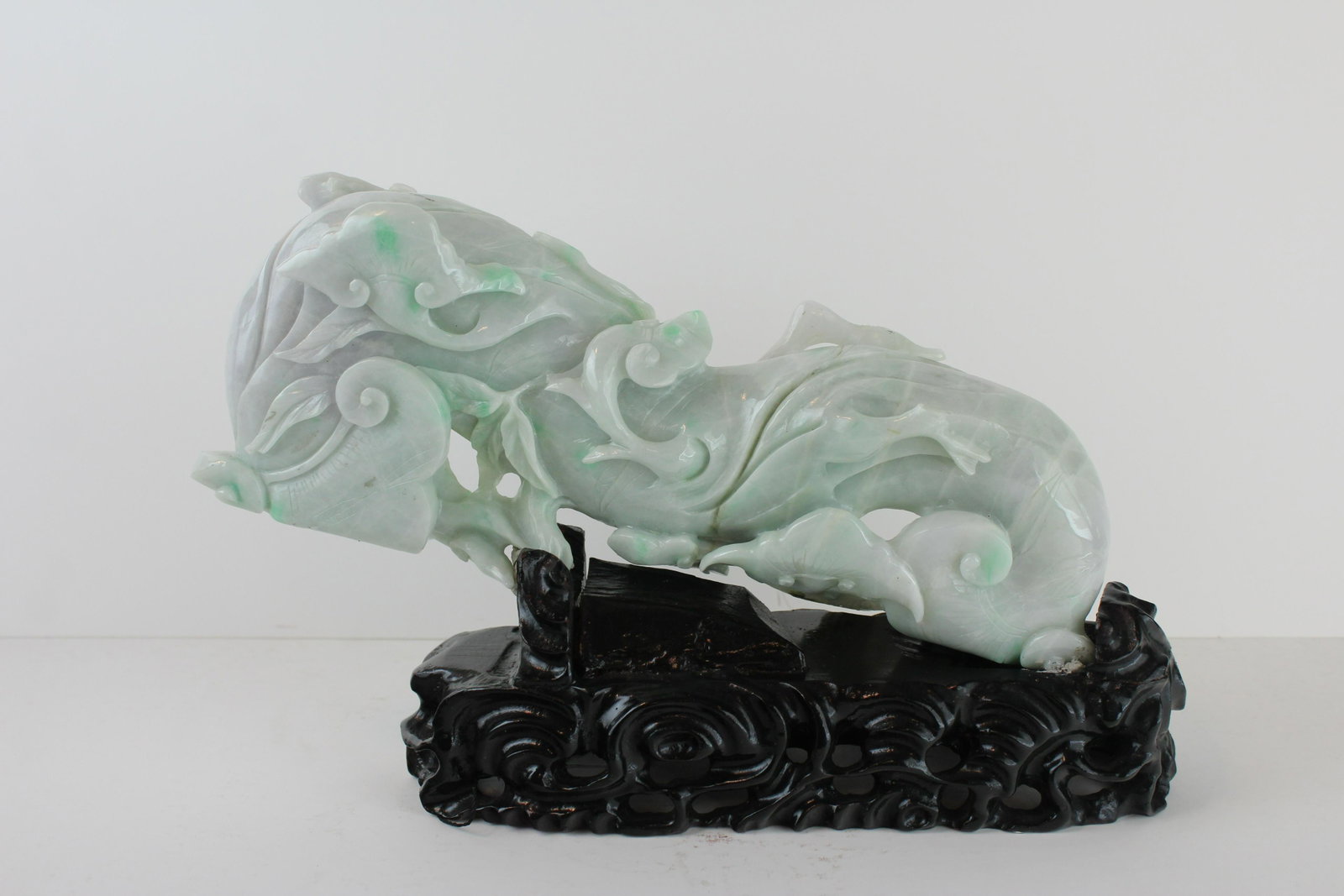 Chinese Jadeite Tree Vine Carving: Chinese Jadeite Tree Vine Carving. Depicting an ornately carved curling tree vine, adorned with leaves and smaller vines. The Chinese jadeite of translucent pale icy green with brushes of bright green