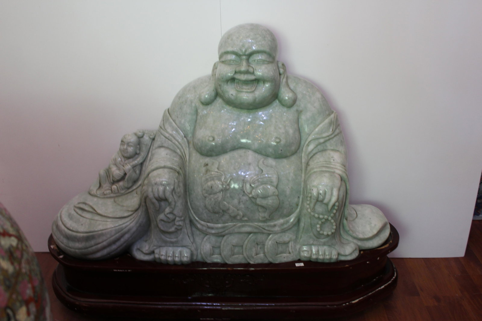 Impressive large Chinese Jadeite Buddha Carving: Impressive large Chinese Jadeite Smiling Buddha Carving. Depicting a sitting buddha adorned in a robe with a carved silver ingot in one hand (sycee) and a bead charm (possibly pearls) in the other. Th