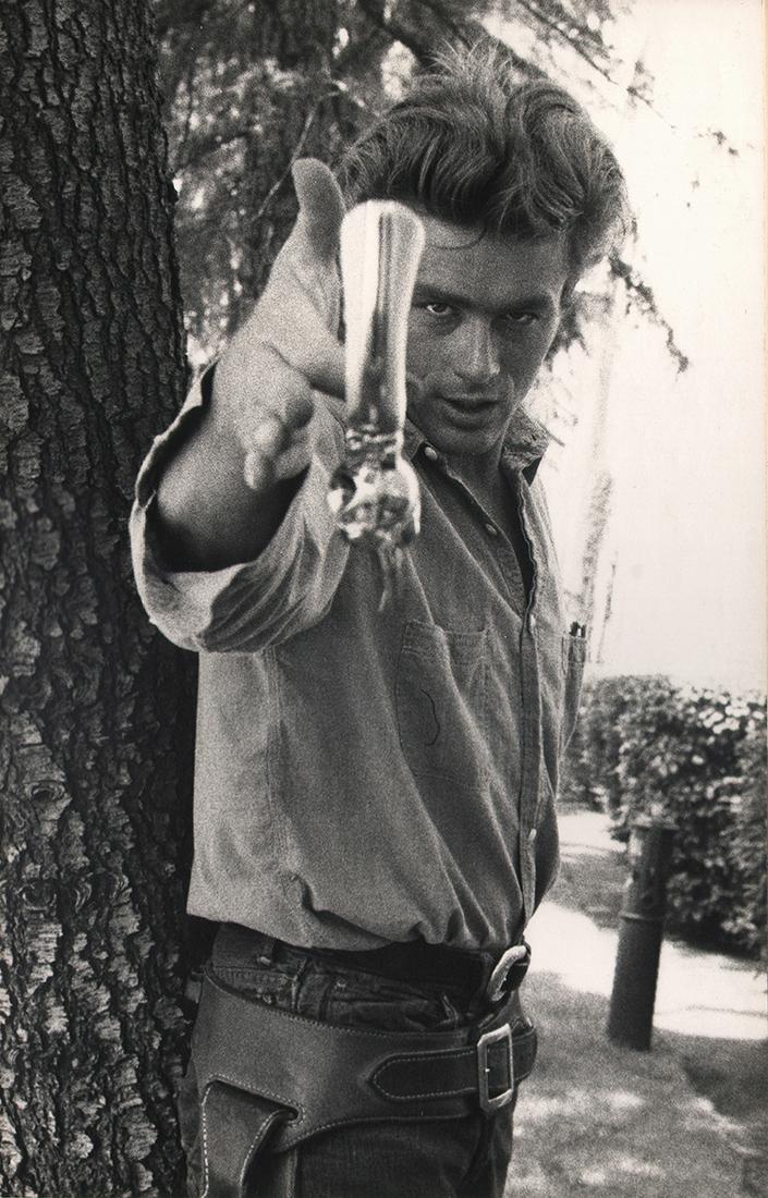 CALIFORNIA MID-CENTURY: Sanford H. Roth: Sanford H. Roth, James Dean on the set of 'Giant' Twirling Pistol, c. 1954/55, Vintage gelatin silver print, 13.5" x 8.5", mounted 16" x 13". Signed "S.H. Roth in ink on mount recto. Artist's credit s